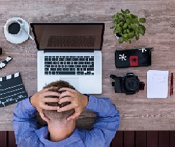 Trabajador delante de un ordenador con signos de agobio