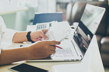 Teclado de ordenador con una persona leyendo notas