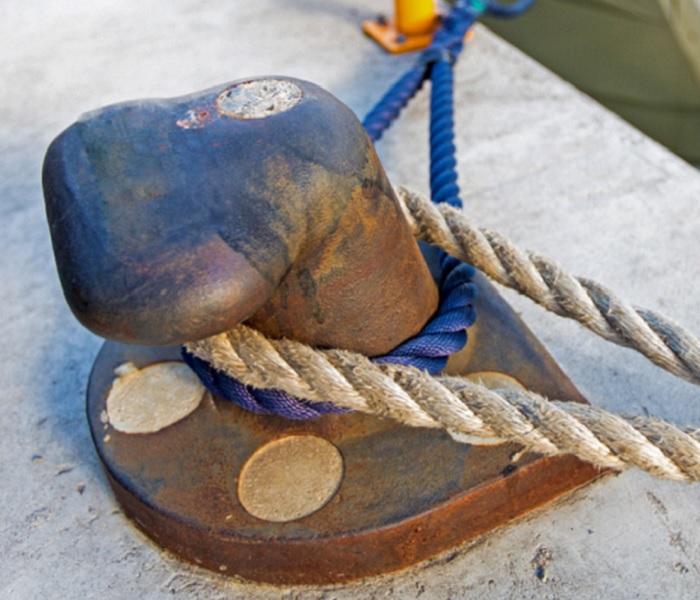 Noray o bolardo del muelle con dos sogas atadas