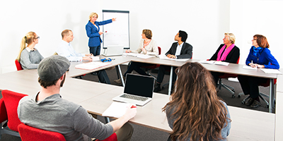 Una profesora dando un curso a unos alumnos