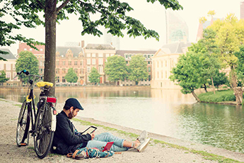 Ciclista sentado en el parque leyendoun libro