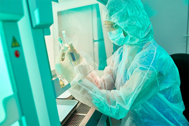 Técnico de laboratorio trabajando ante una cabina de seguridad biológica.
