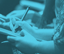 Imagen de unas manos de mujer escribiendo sobre un cuaderno