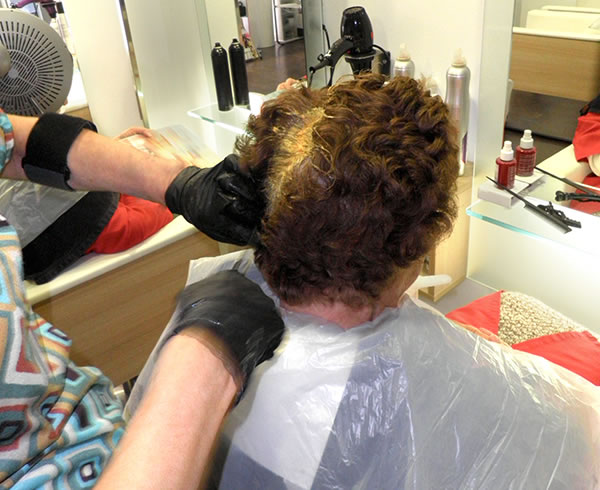 Aplicación de coloración de cabello que luego será cortado: obsérvese el trabajo directo con las manos