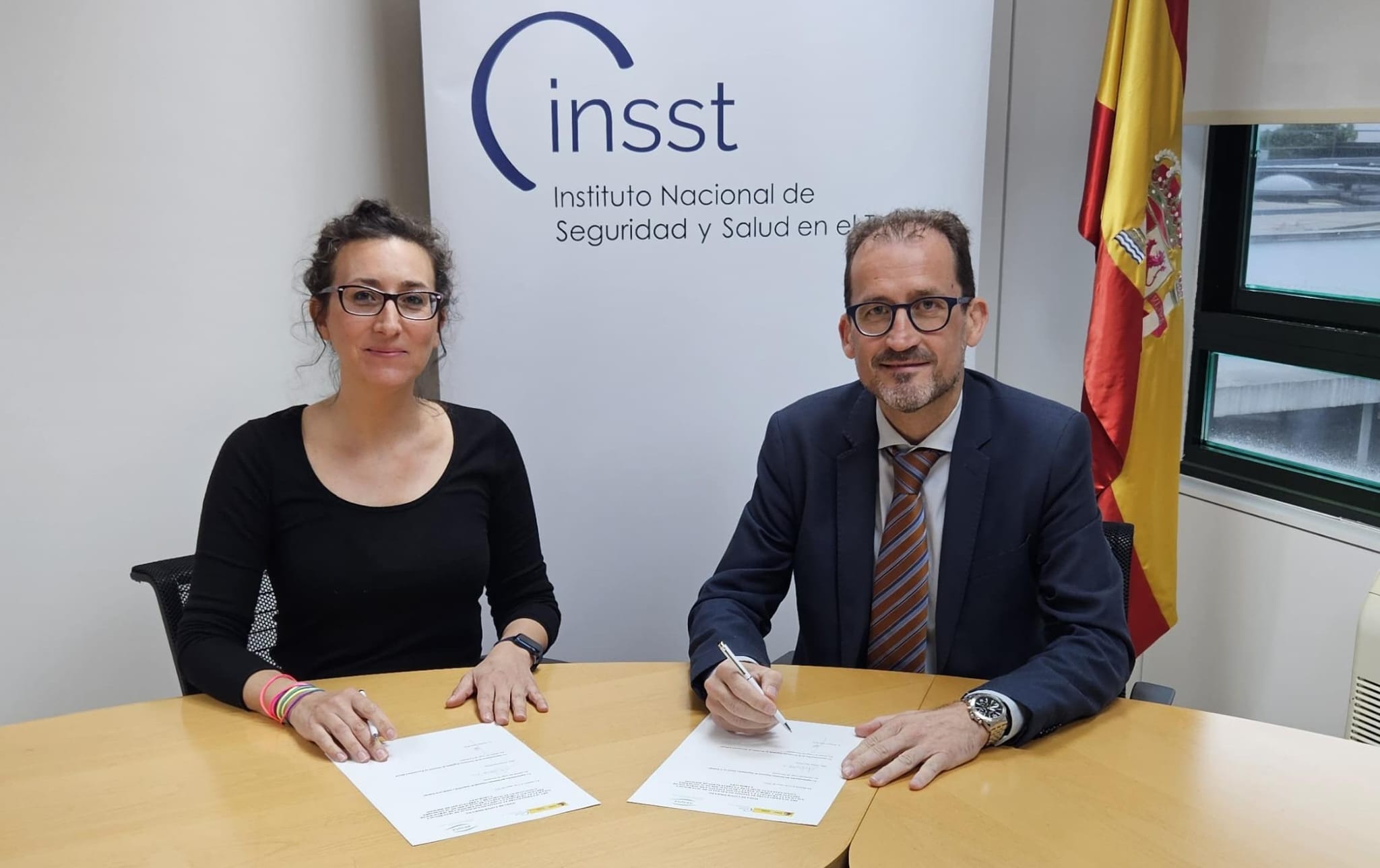 Fotografía de la directora del INSST y el director de AESPLA  durante la firma de un acuerdo conjunto